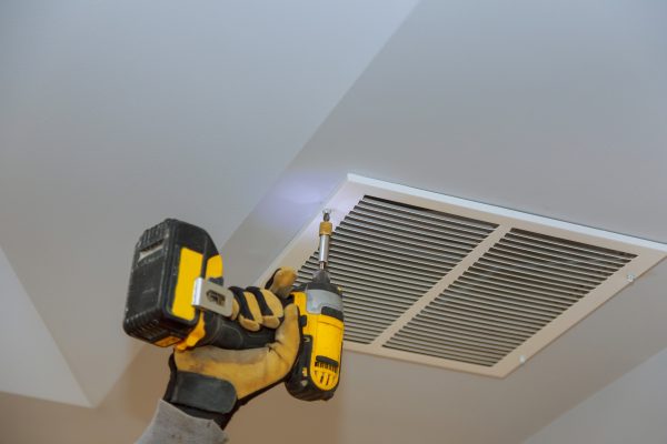 The process of installing mounting skin ceiling covered by metalic ventilation cover in under-construction site.
