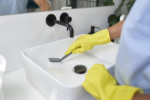 Unrecognizable senior woman cleaning the washbasin